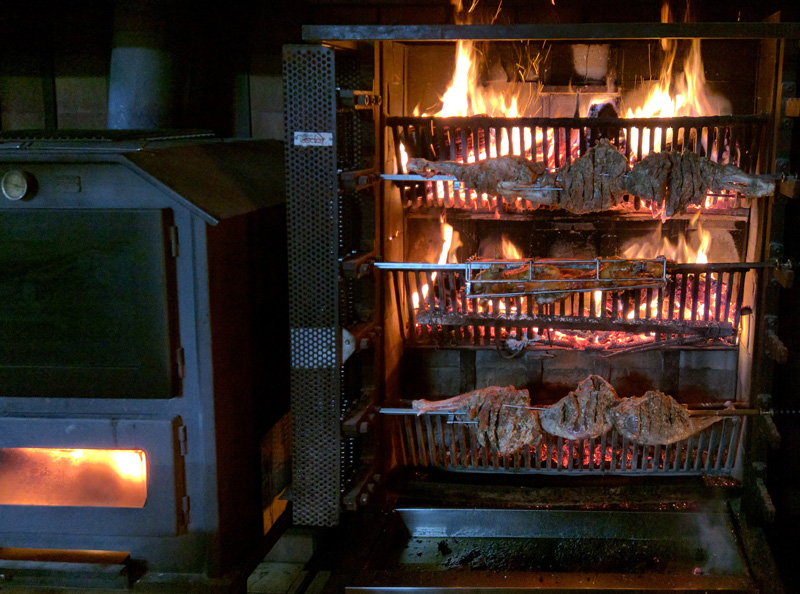 Horno de leña con los asados en preparación
